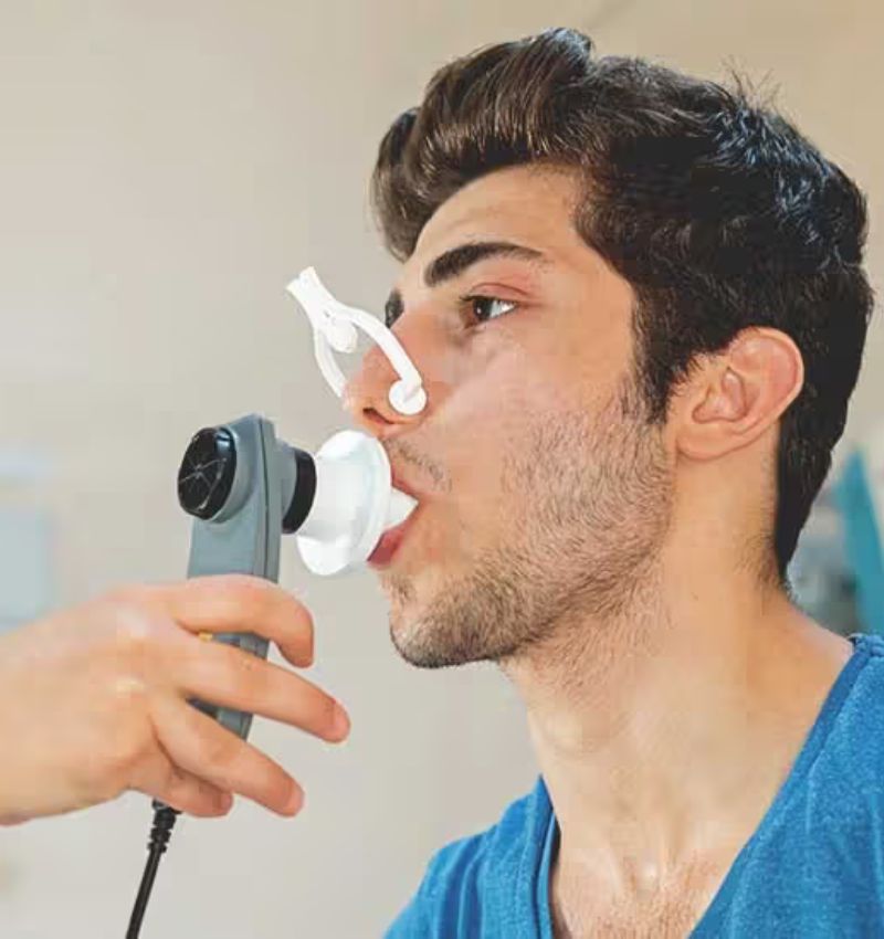 Paciente joven usando equipo de terapia inhalada